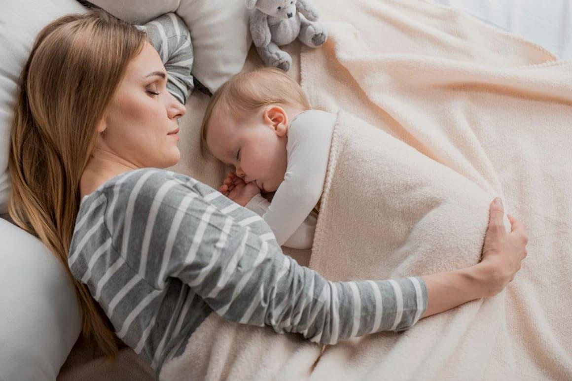 Madre duerme con un bebé